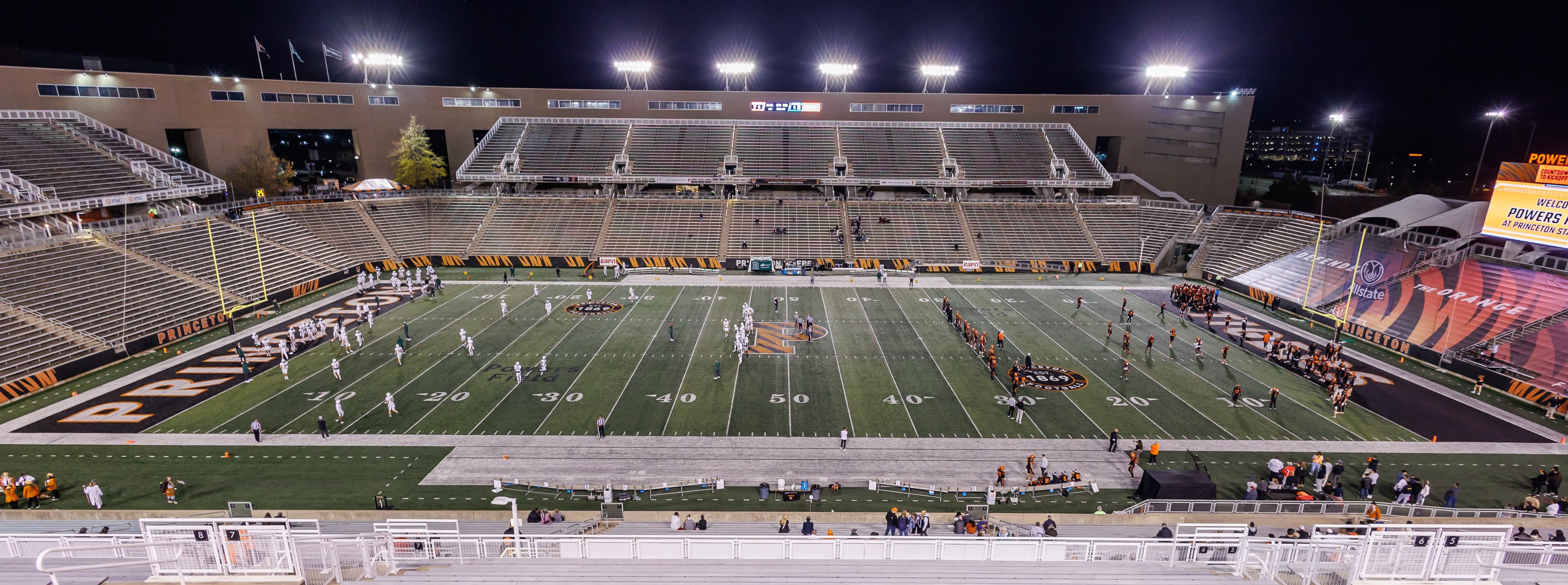 A football field illuminated beneath stadium lights